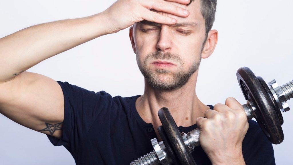 man in black crew neck t-shirt holding black dumbbell