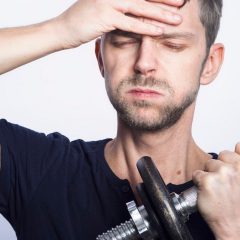 man in black crew neck t-shirt holding black dumbbell